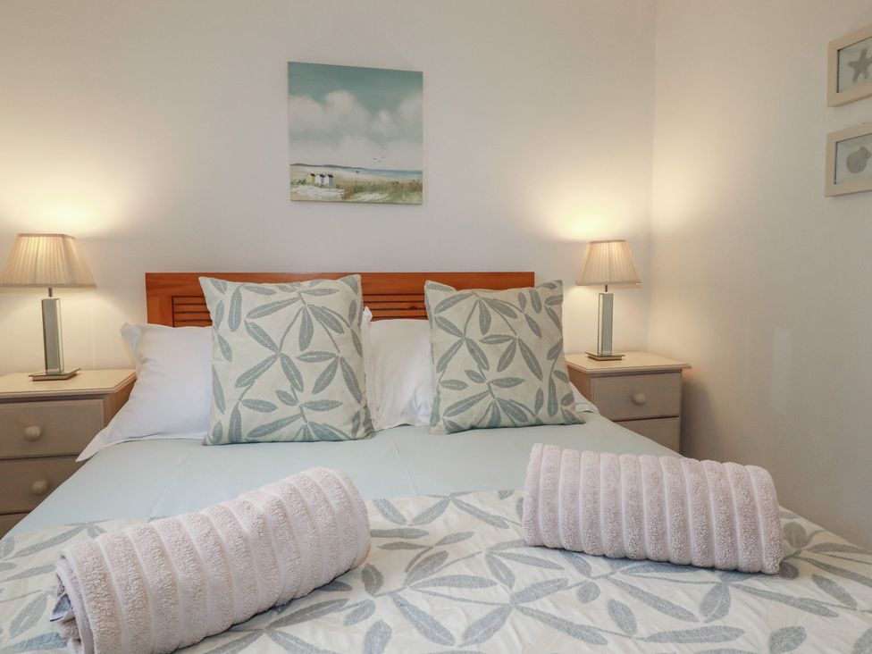 A bedroom with a bed and nightstands at Atlantic View in Tintagel