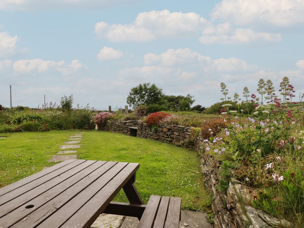 A garden with a table and flowers at Atlantic View in Tintagel