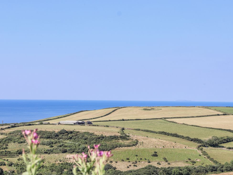 A view of fields and ocean from a distance at Atlantic View in Tintagel