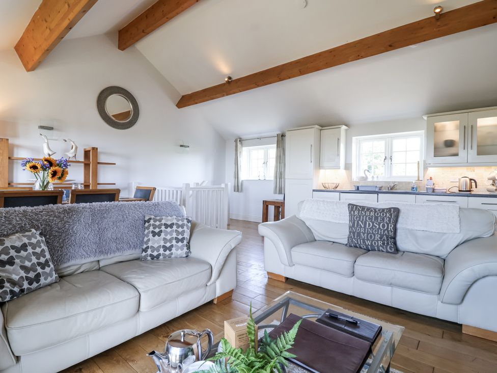 A living room with a sofa and dining table at Atlantic View in Tintagel