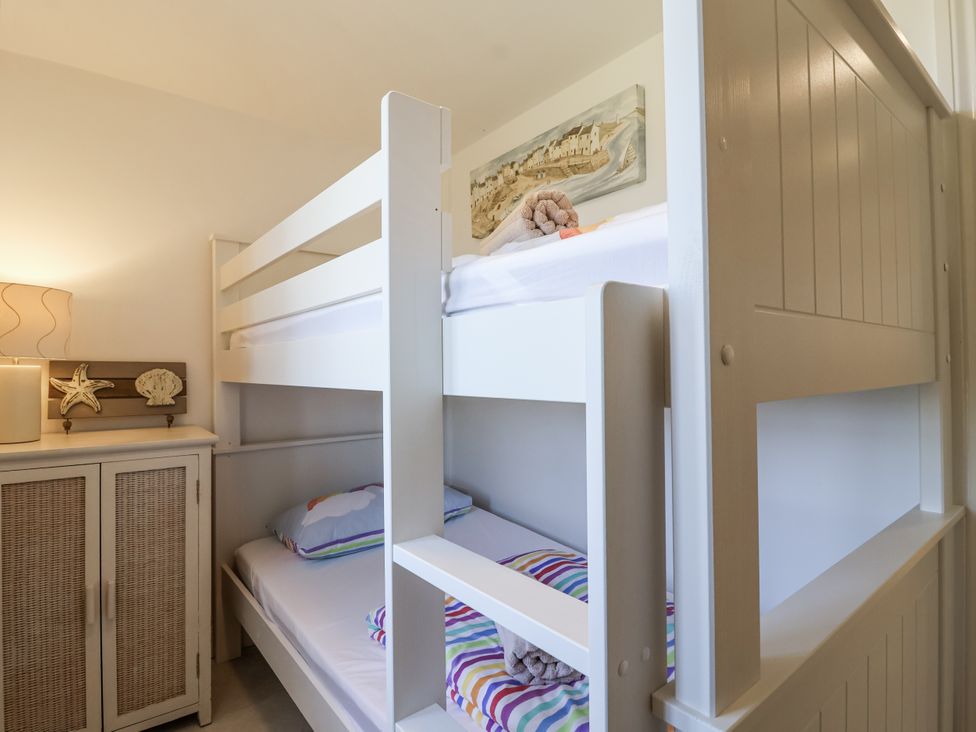 A bedroom with a bunk bed and cabinet at Atlantic View in Tintagel