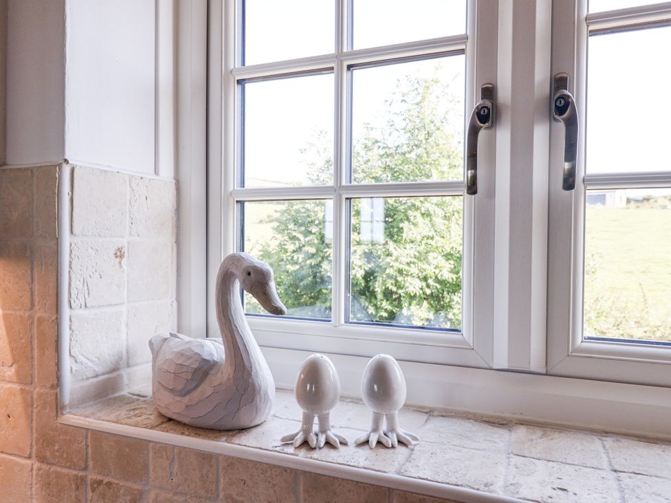 A kitchen window with a decorative swan and eggs at Atlantic View in Tintagel