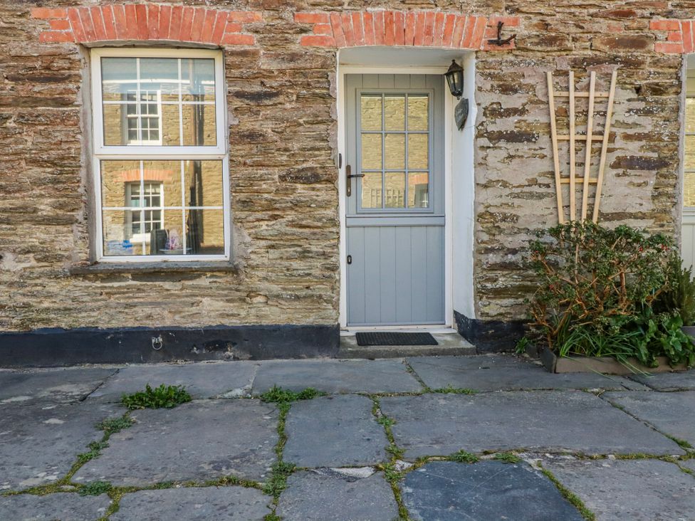 An outdoor view of a gray door and windows at Kingfisher Cottage in Edmonton, near Wadebridge
