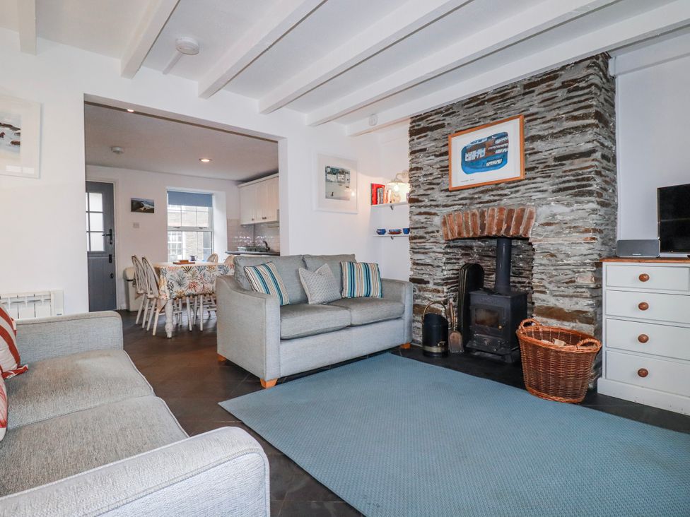 A living room with a fireplace and sofa at Kingfisher Cottage in Edmonton, near Wadebridge