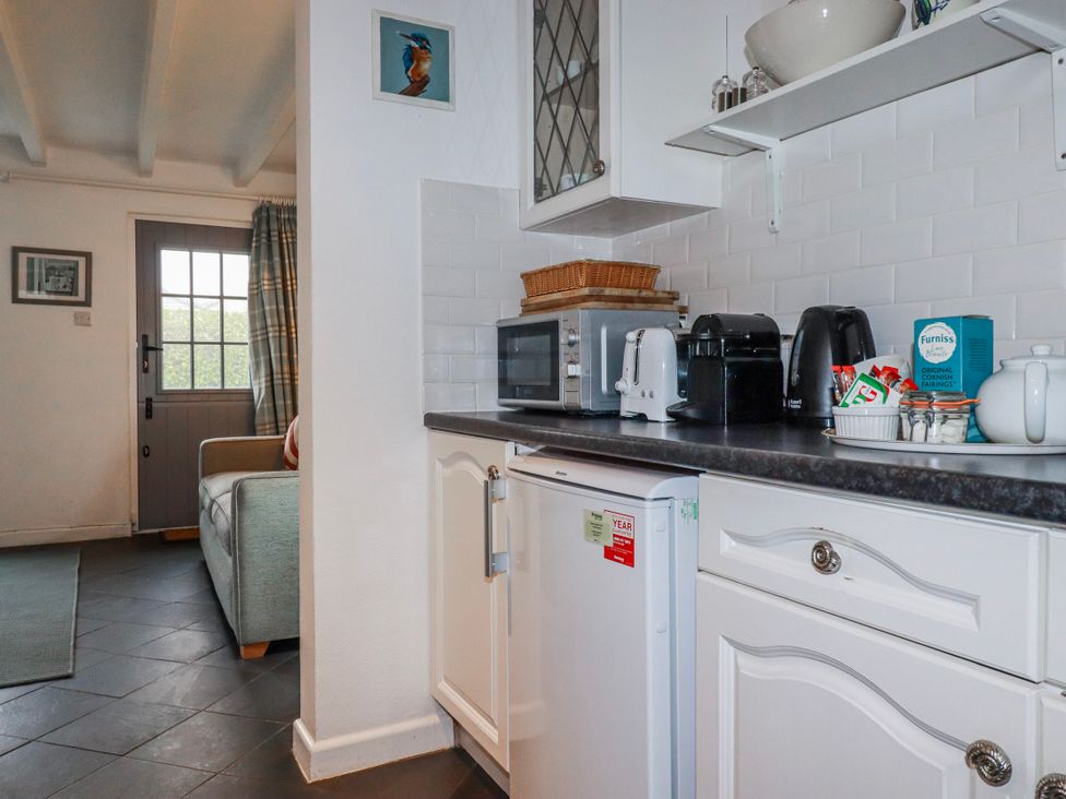 A kitchen with various appliances and countertop items at Kingfisher Cottage, Edmonton, near Wadebridge