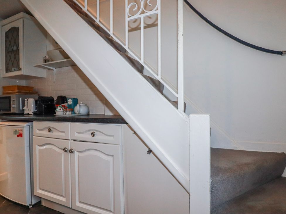 A kitchen with stairs leading to upper level at Kingfisher Cottage, Edmonton, near Wadebridge