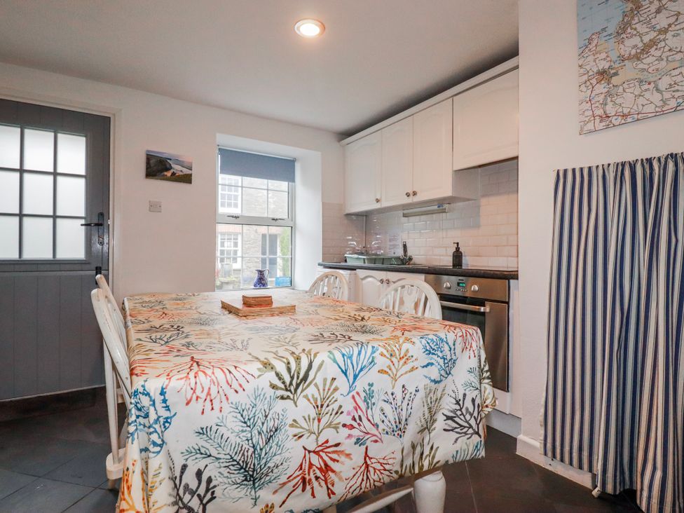 A kitchen with a table and chairs at Kingfisher Cottage, Edmonton, near Wadebridge