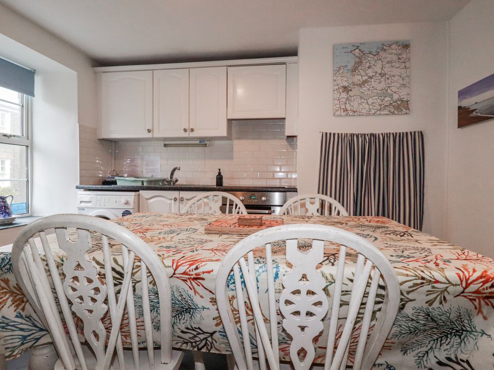 A kitchen with a table and chairs at Kingfisher Cottage, Edmonton, near Wadebridge