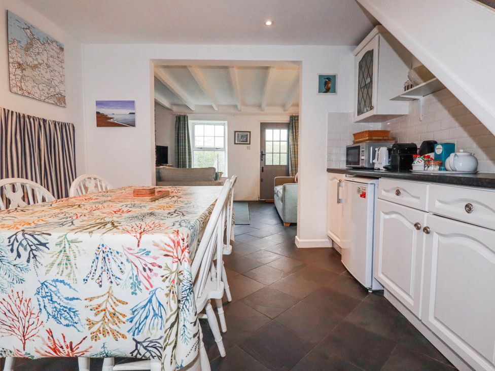 A kitchen with a dining table and chairs at Kingfisher Cottage, near Wadebridge