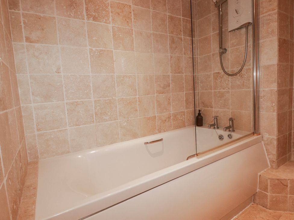 A bathroom with a bathtub and shower at Kingfisher Cottage in Edmonton, near Wadebridge