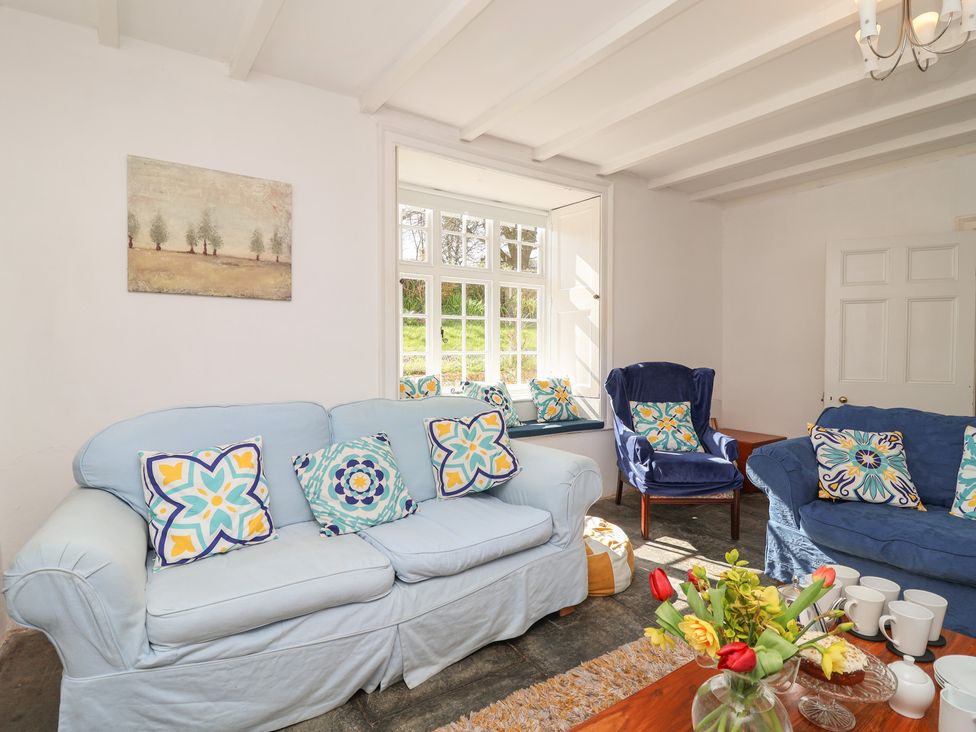 A living room with sofas and a coffee table at Tregonhawke Farmhouse in Millbrook