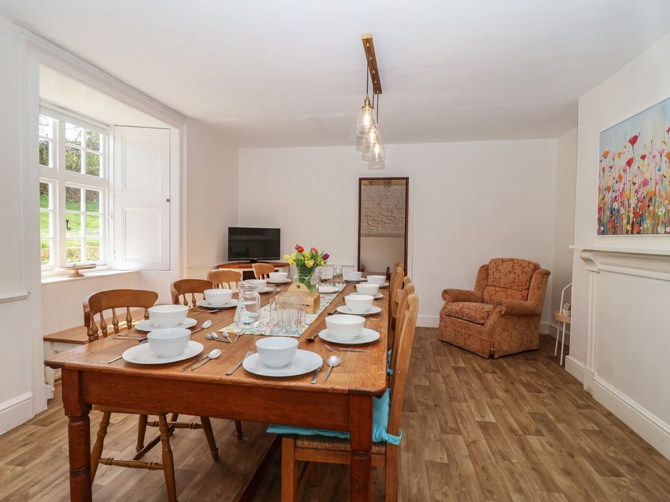 A dining room with a large table set for a meal at Tregonhawke Farmhouse Millbrook
