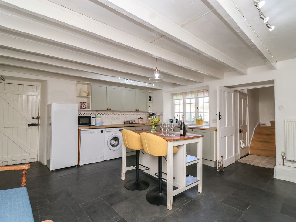 A kitchen with appliances and a table at Tregonhawke Farmhouse in Millbrook