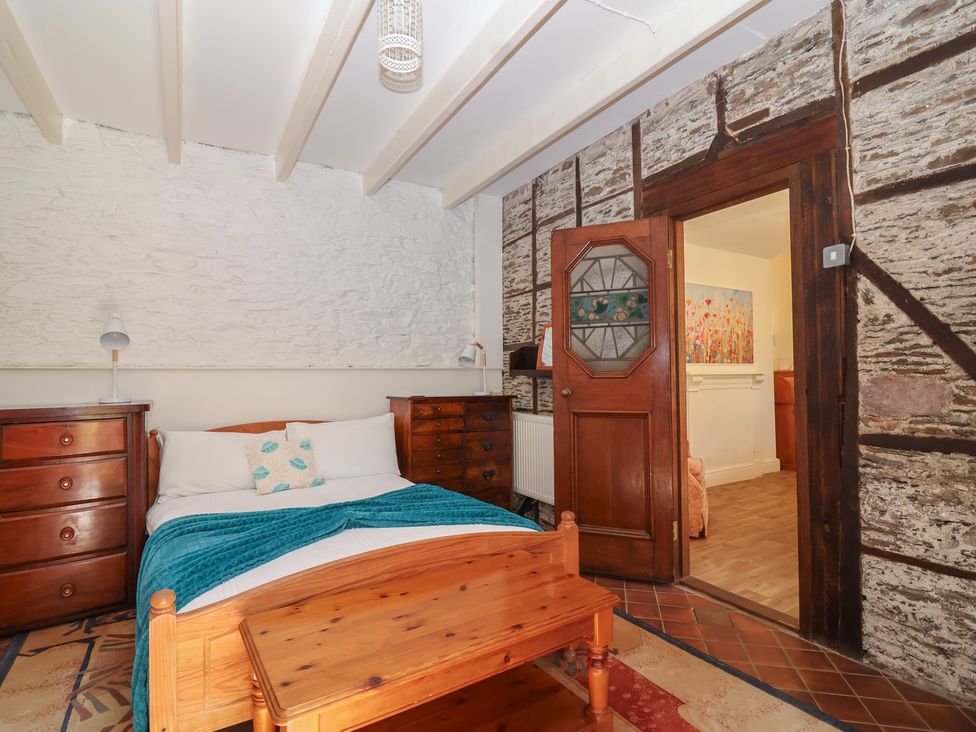 A bedroom with a bed and wooden furniture at Tregonhawke Farmhouse in Millbrook