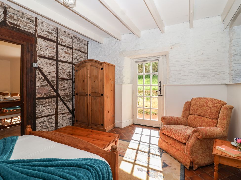 A bedroom with a bed and wardrobe at Tregonhawke Farmhouse in Millbrook