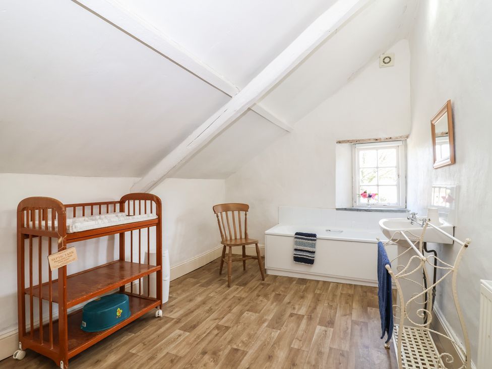 A bathroom with a changing table and bathtub at Tregonhawke Farmhouse in Millbrook