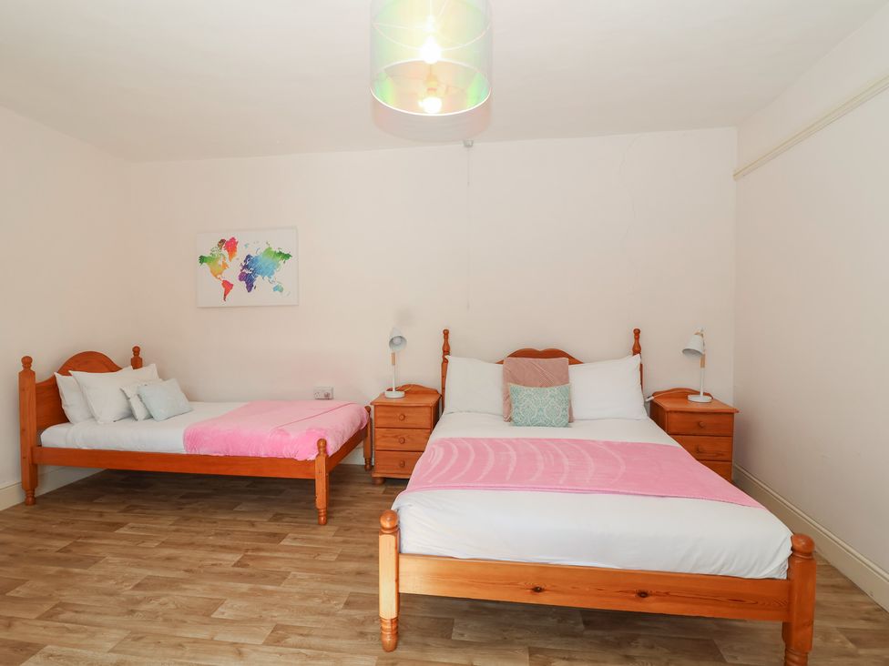 A bedroom with two beds and bedside tables at Tregonhawke Farmhouse in Millbrook