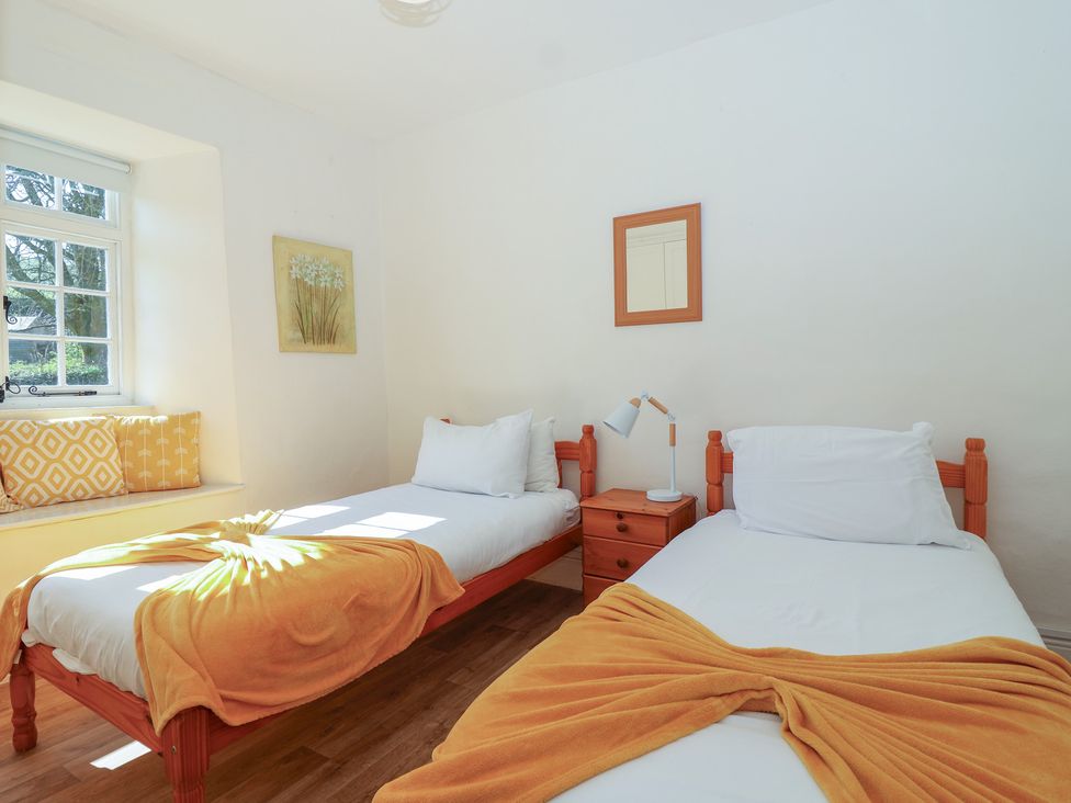 A bedroom with two beds and a window at Tregonhawke Farmhouse Millbrook
