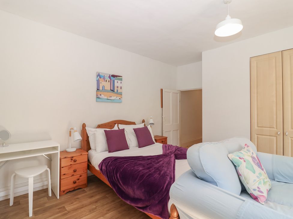 A bedroom with a bed and a desk at Tregonhawke Farmhouse in Millbrook
