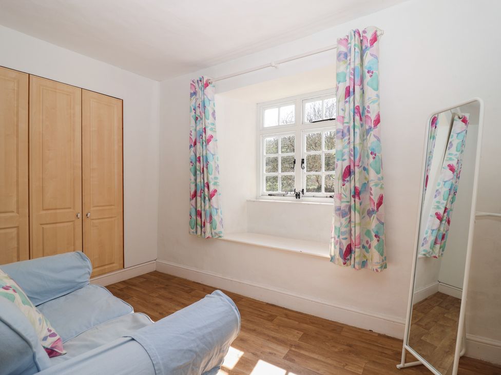 A sitting room with a sofa and window at Tregonhawke Farmhouse Millbrook
