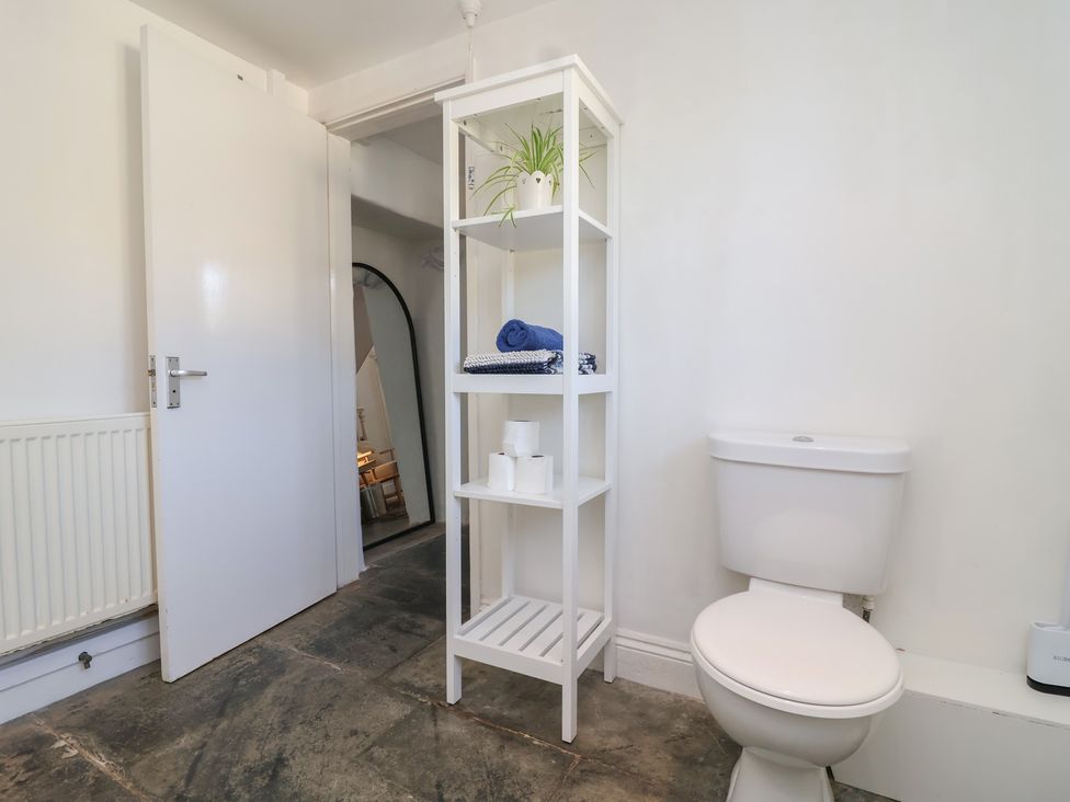 A bathroom with a shelf and toilet at Tregonhawke Farmhouse in Millbrook