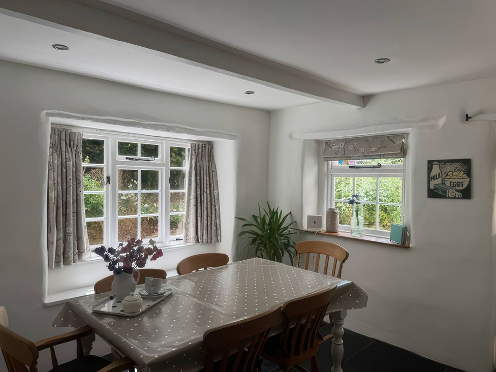 A dining room with a table and chairs at Kingbarth in Lerryn