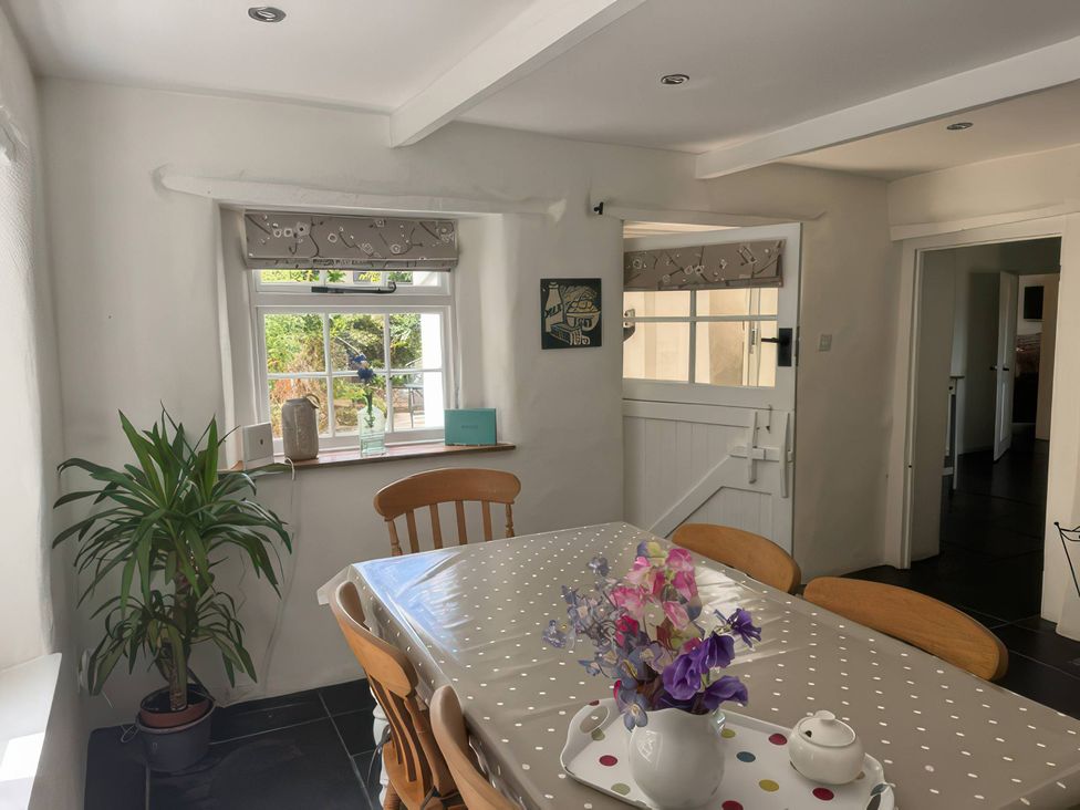 A dining room with a table and chairs at Kingbarth in Lerryn