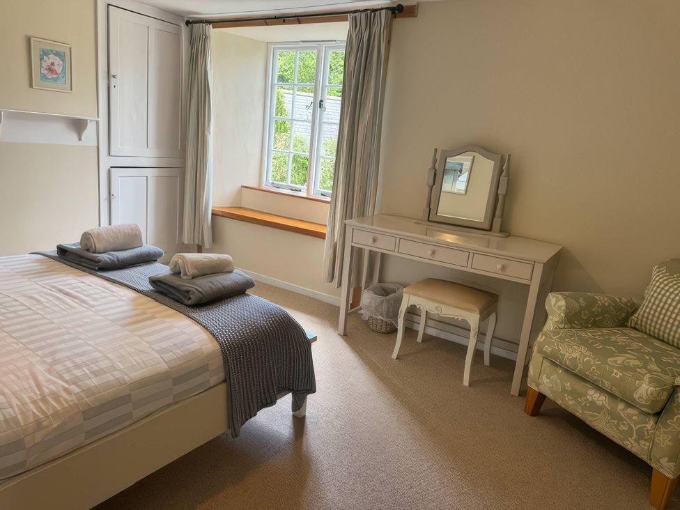 A bedroom with a bed and dresser at Kingbarth in Lerryn