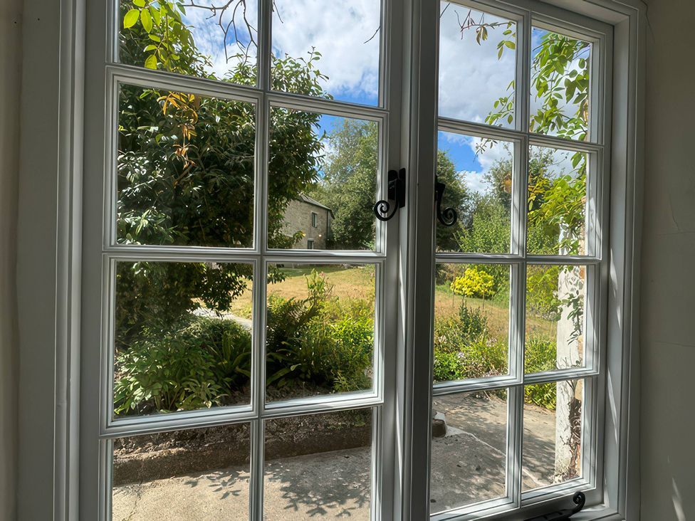 A view from a window showing a garden with plants and grass at Kingbarth in Lerryn