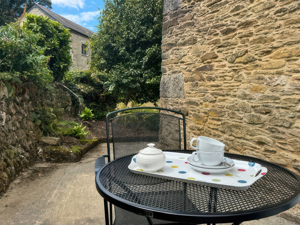 An outdoor seating area with a table set for tea at Kingbarth in Lerryn