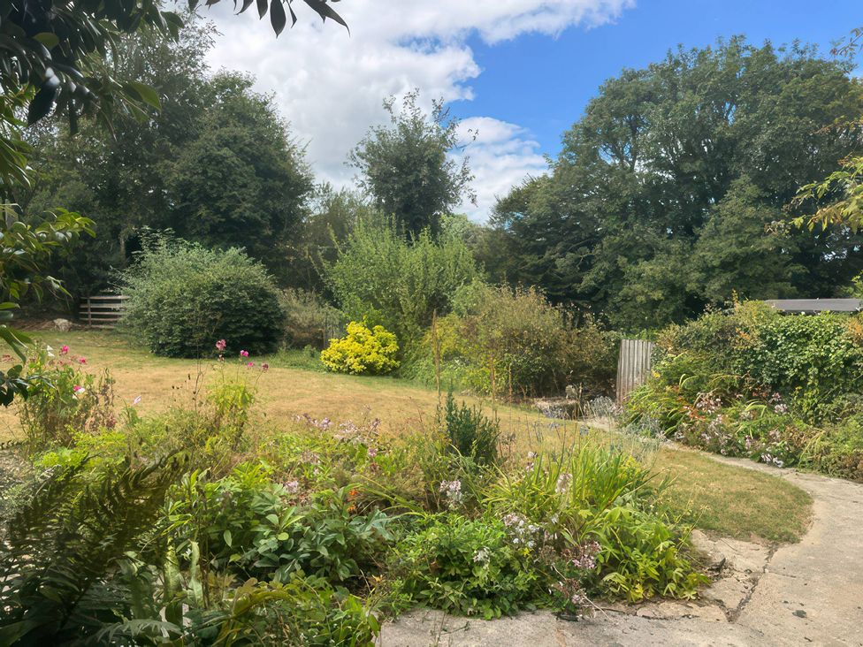 A garden with grass, flowers, and trees at Kingbarth in Lerryn