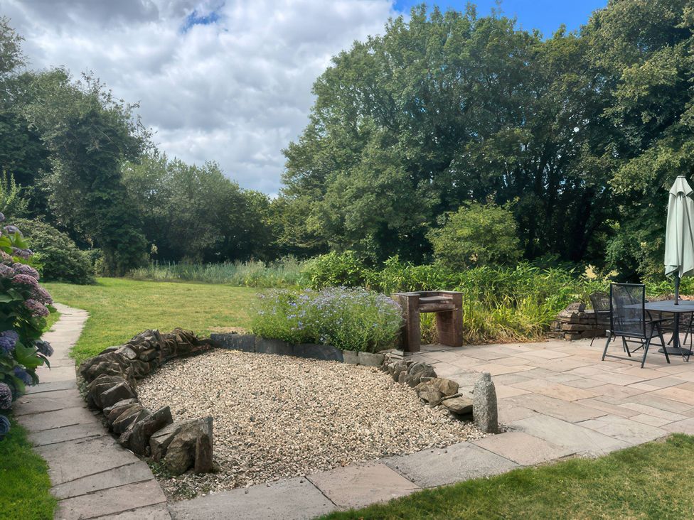 A garden with a gravel area and patio furniture at Kingbarth in Lerryn