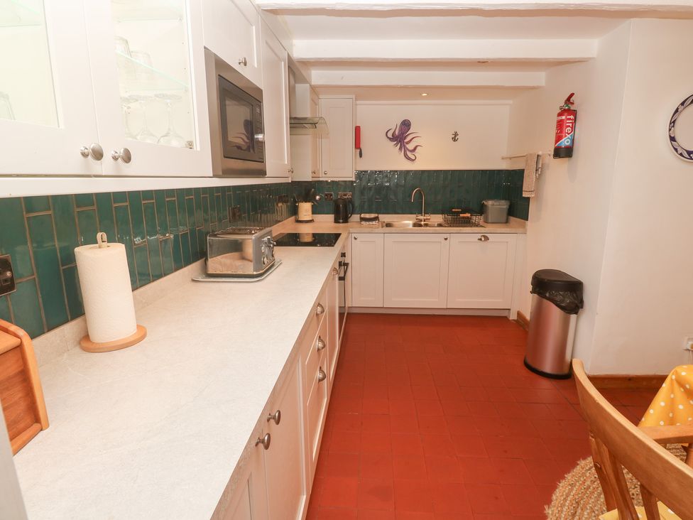 A kitchen with a countertop and appliances at Mural Cottage Mousehole