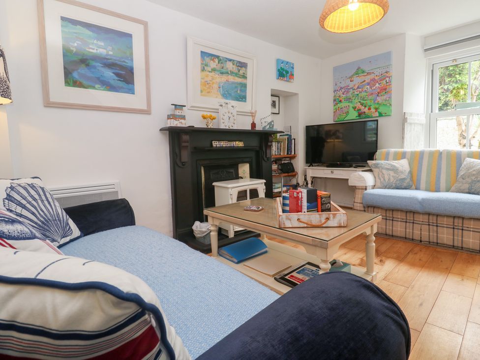 A living room with a television and artwork at 2 The Cottages in Ludgvan