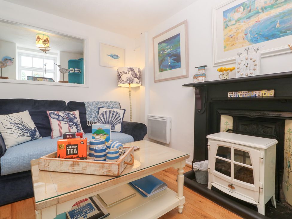 A living room with a sofa and a table at 2 The Cottages in Ludgvan