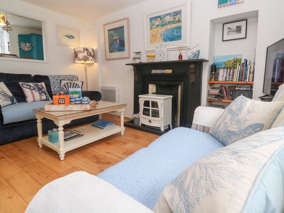 A living room with a television, sofa, and a coffee table at 2 The Cottages Ludgvan