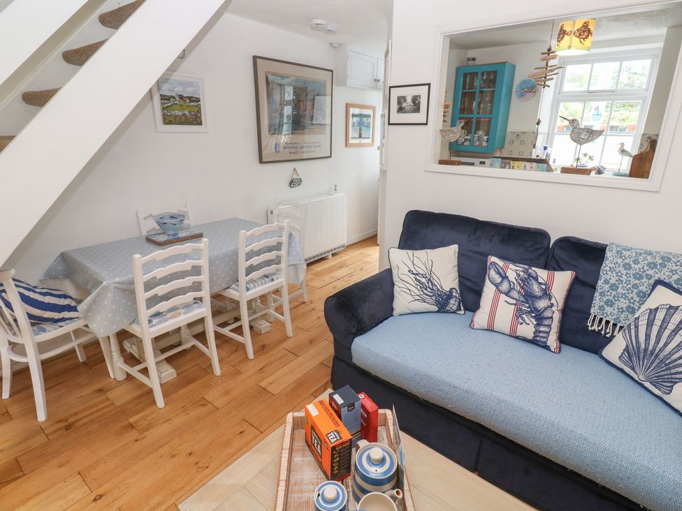 A living room with a sofa and dining table at 2 The Cottages Ludgvan