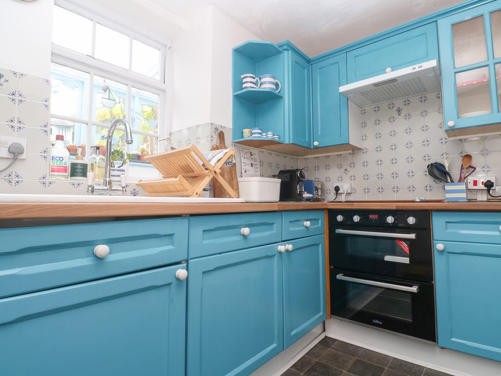 A kitchen with blue cabinets and an oven at 2 The Cottages Ludgvan