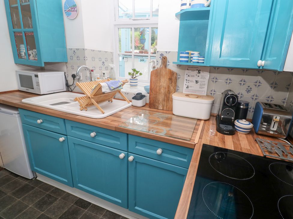 A kitchen with blue cabinets and appliances at 2 The Cottages Ludgvan