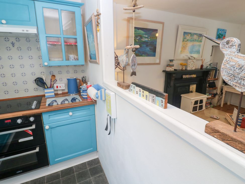 A kitchen with blue cabinetry and wooden countertop at 2 The Cottages Ludgvan