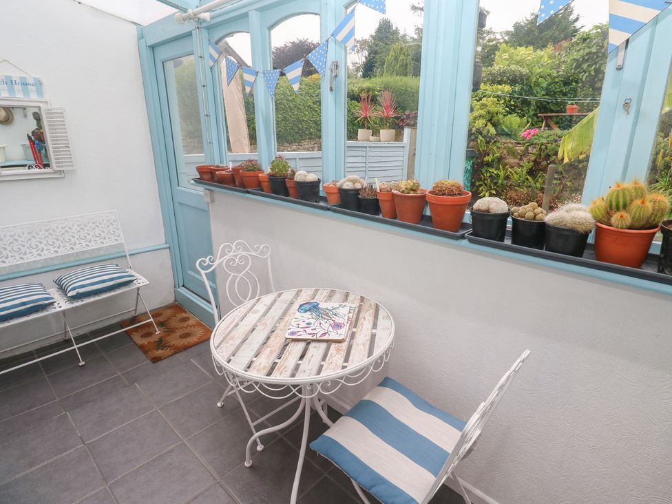 A conservatory with a table and chairs at 2 The Cottages, Ludgvan