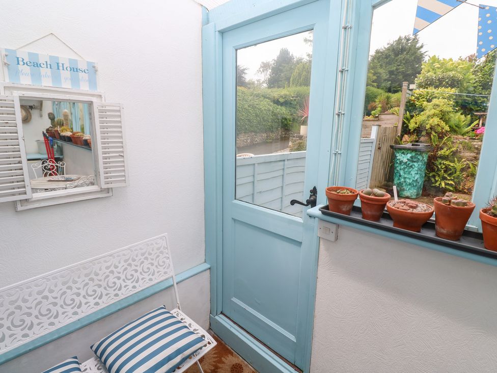 A hallway with a decorative mirror and plant pots at 2 The Cottages Ludgvan