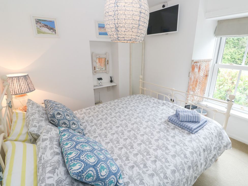 A bedroom with a bed and television at 2 The Cottages in Ludgvan