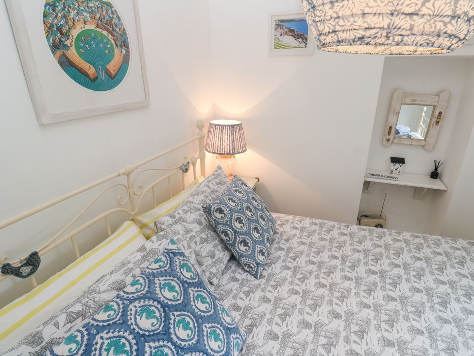 A bedroom with a bed and bedside lamp at 2 The Cottages in Ludgvan
