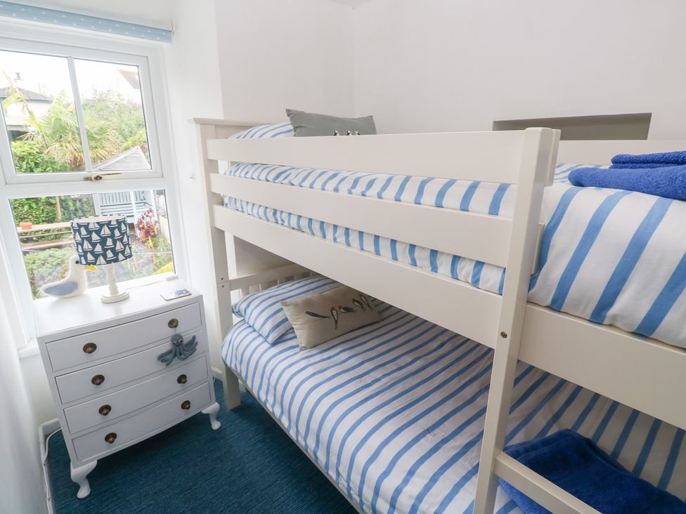 A bedroom with a bunk bed and nightstand at 2 The Cottages Ludgvan
