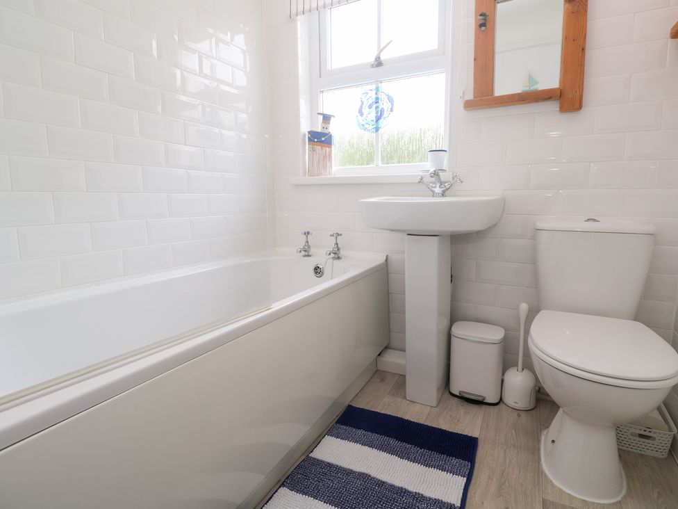 A bathroom with a bathtub, sink and toilet at 2 The Cottages Ludgvan
