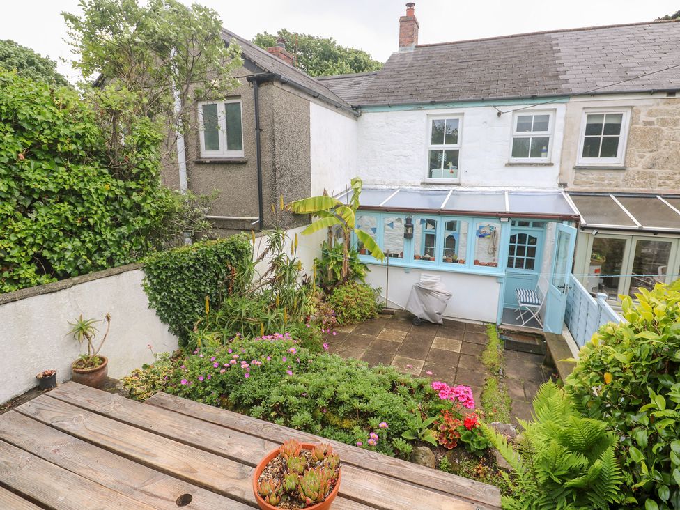 A garden with plants and a wooden table at 2 The Cottages Ludgvan