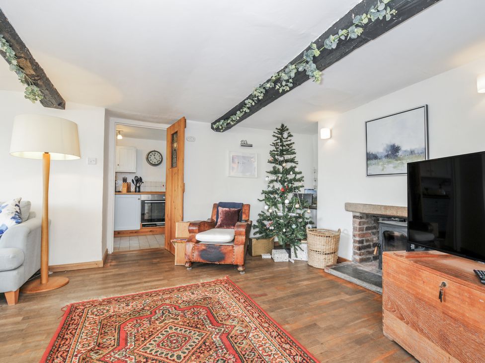 A living room with a Christmas tree and sofa at Clamoak Cottage near Bere Alston