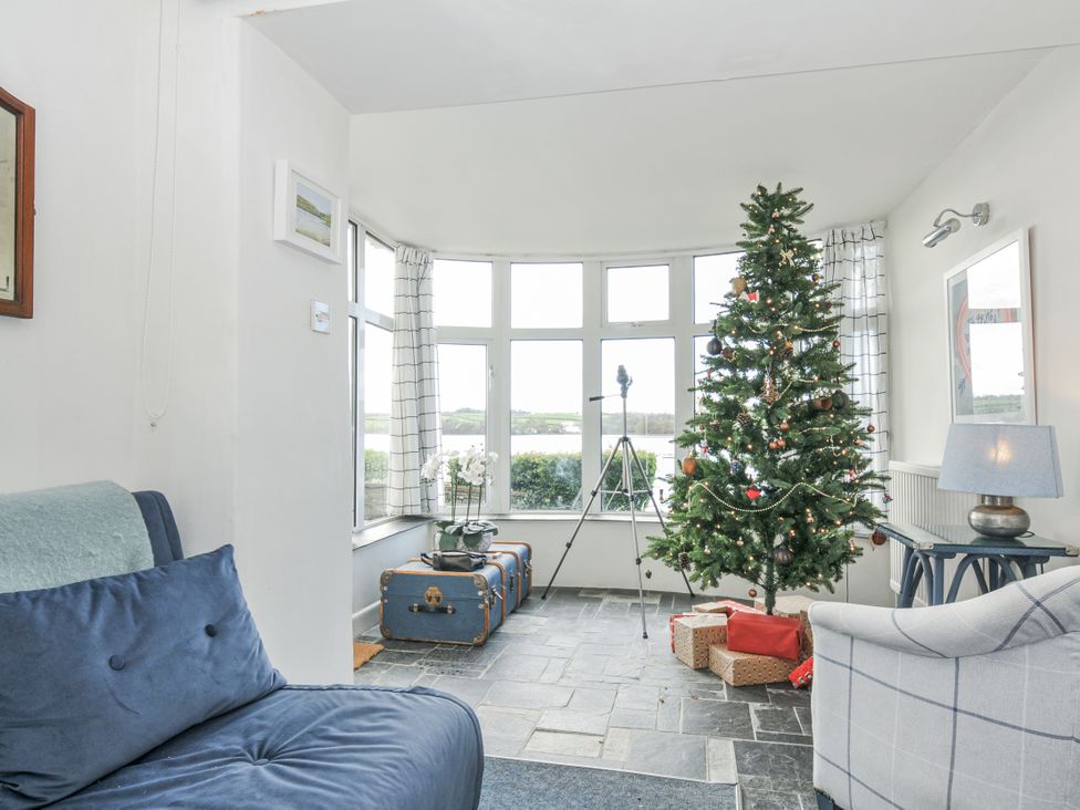 A snug room with a Christmas tree and gifts at Clamoak Cottage Clamoak near Bere Alston