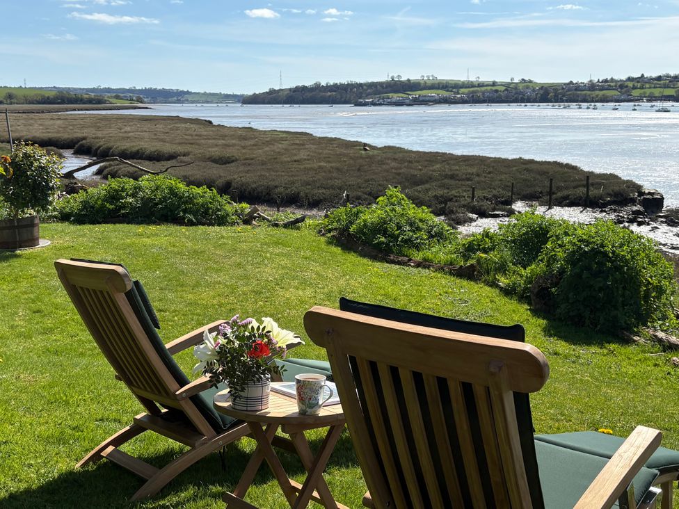 A garden with deck chairs and a flower arrangement at Clamoak Cottage Clamoak near Bere Alston
